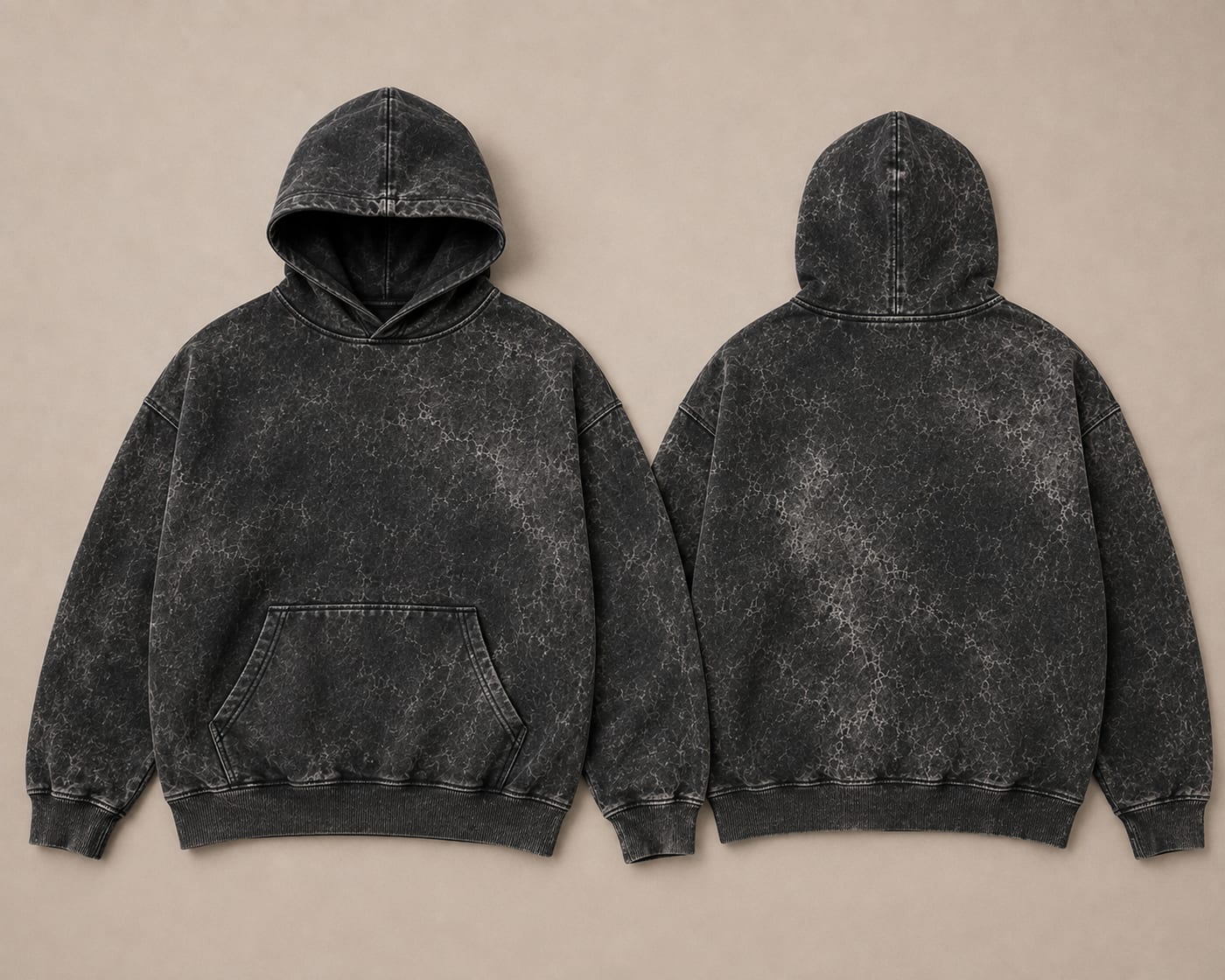 Front and back of a black 450 GSM brushed fleece acid wash hoodie laid flat side by side