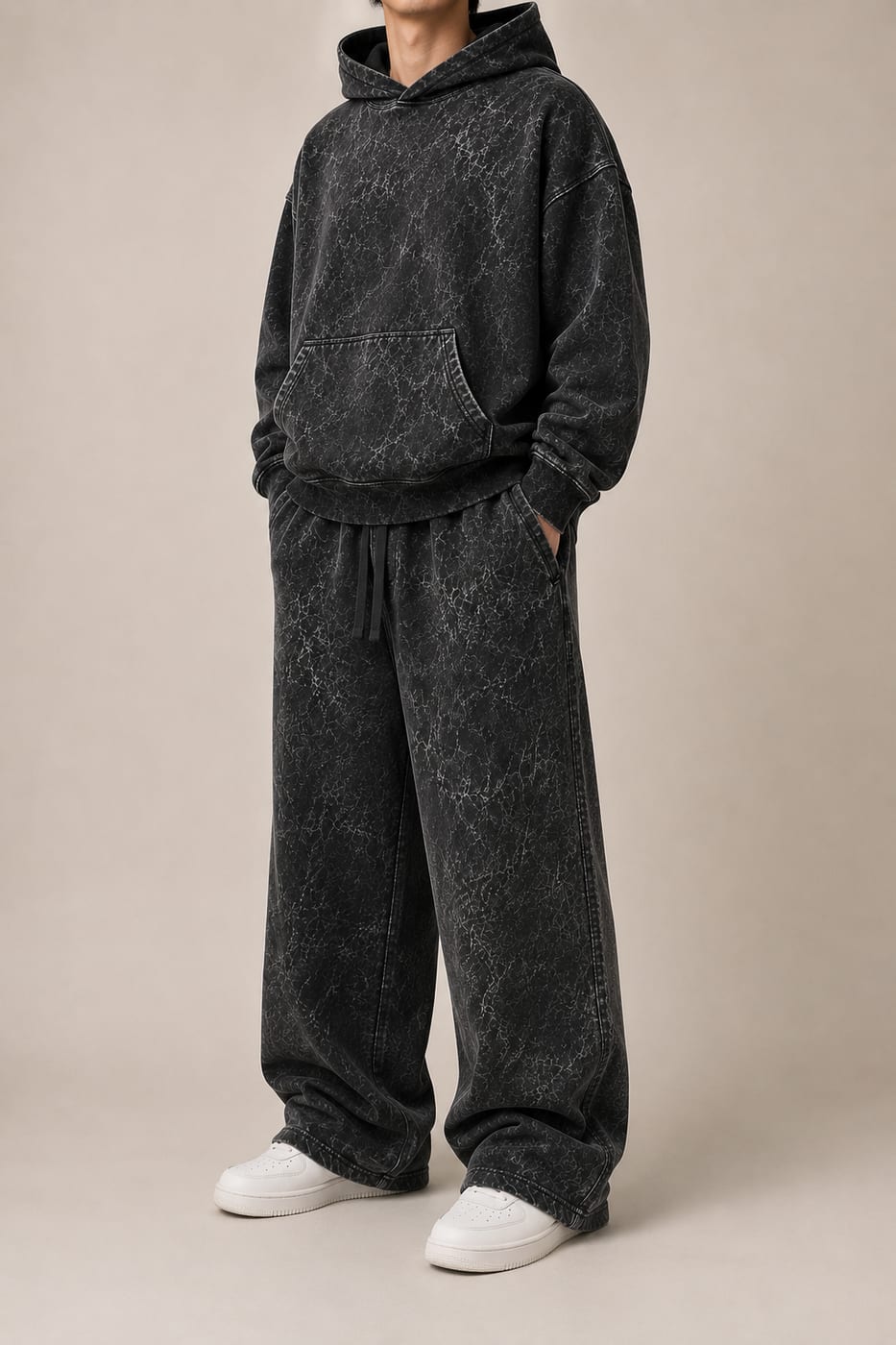 Model wearing a black 450 GSM oversized acid wash hoodie with matching wide-leg sweatpants