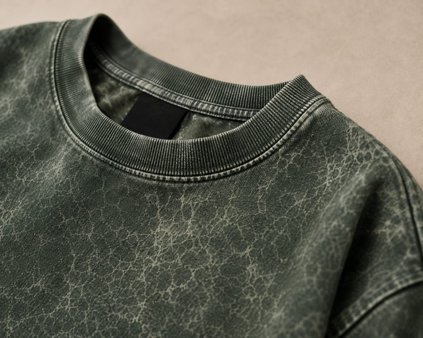 Close-up of the ribbed crew neck and shoulder seam on an olive 300 GSM acid wash heavyweight tee