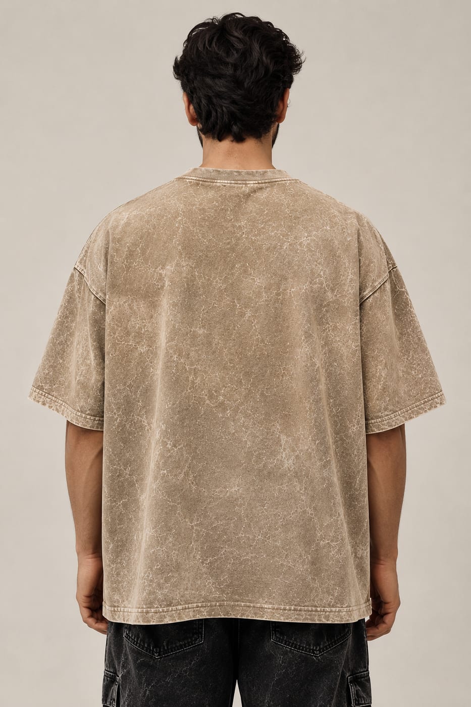 Model seen from behind wearing a sand 300 GSM oversized acid wash tee, showing the drop-shoulder drape